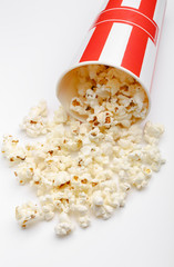 Popcorn in red and white cardboard box. Popcorn border isolated on white. Film. Fast food. Corn