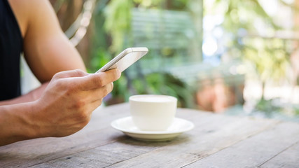 Man using a smartphone in a coffee shop.
