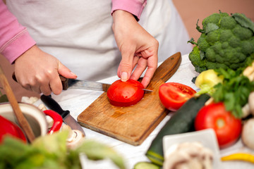 Woman cutting tomato for salad