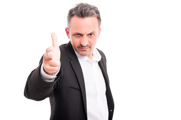 Serious young man doing a shoot gun gesture