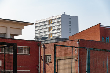 Council housing high rise flats in East London surrounded by red brick industrial looking buildings