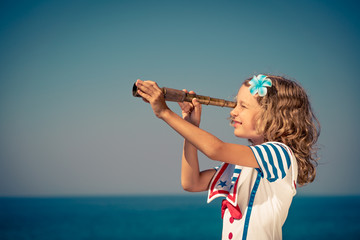 Child with vintage spyglass on summer vacation