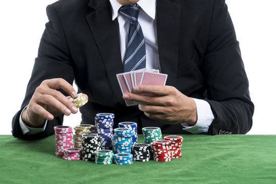 The man in black suit holding some chips for into the bets