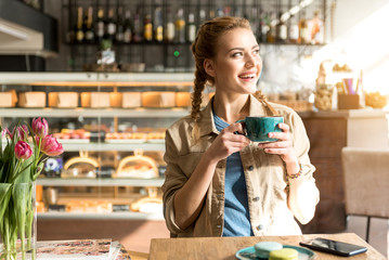 Happy woman drinking cup of coffee