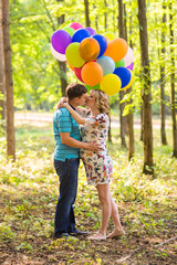 Fototapeta premium young couple man and his pregnant wife with balloons outdoors