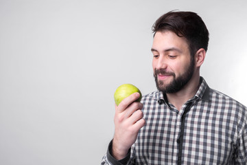 Men eats an apple. bearded guy holding an apple. vegetarian preparing dinner