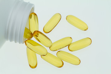 Fish oil capsules in white bottle isolated on white background