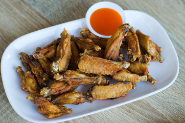Fresh fried chicken on a white plate set on a wood table