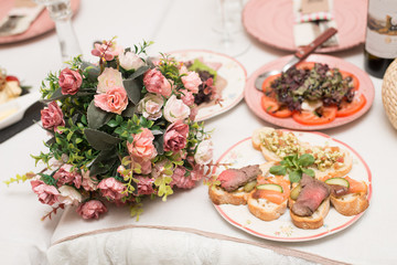 Obraz na płótnie Canvas Festive table with snacks and flowers