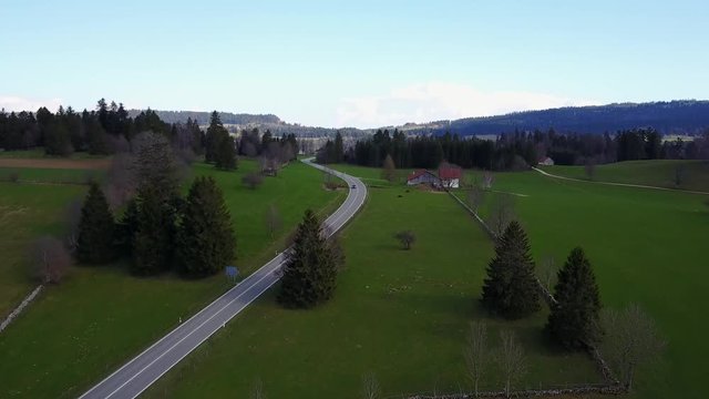 Following Ferrari on road in Jura - aerial
