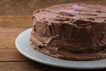 Rustic homemade whole chocolate cake on wood table and