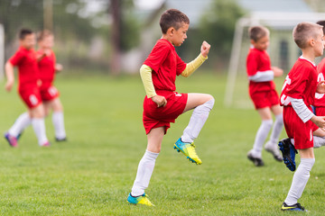 Kids soccer football - children players exercising before match on soccer field