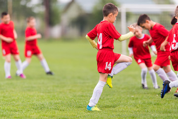 Obraz premium Kids soccer football - children players exercising before match on soccer field
