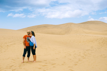 Happy couple waiting baby and photographed against the background of the desert