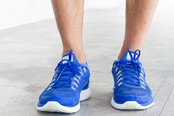 Naklejka premium Man wearing sport shoes on grunge concrete floor, sport concept