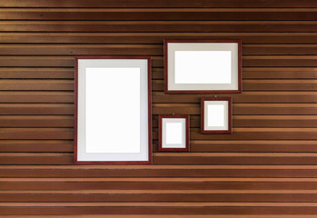 Mockup of blank frames on brown wooden wall, over light