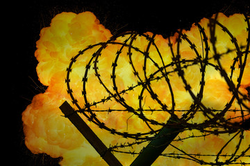 Realistic orange fire explosion behind restricted area barbed wire fence