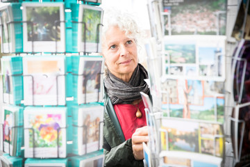 Woman looking at postcards, Bruniquel, France