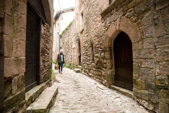 Woman Walking In Narrow Rural Street, Bruniquel, France