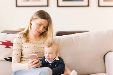 Mother holding baby with smartphone