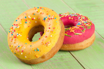 two glazed donut on wooden green background