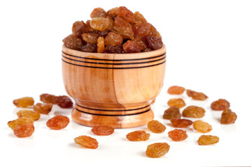 raisins in a wooden bowl isolated on white background