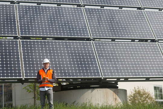 Portrait of young male engineer holding multimeter at solar panel site