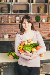 Portrait of happy young woman holding of fresh organic vegetables