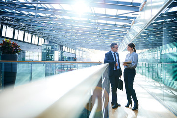 Businessman and woman meeting on office balcony