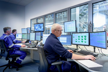 Workers in process control room in oil blending factory