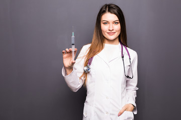 Young doctor woman with syringe on grey background
