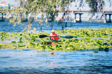 Young people are kayaking on a river in beautiful nature.