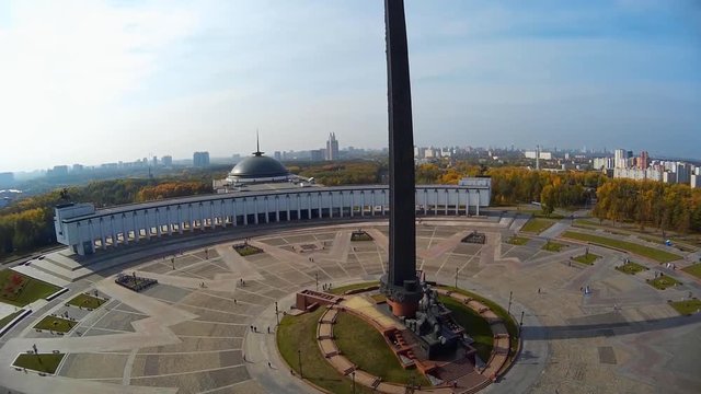 Poklonnaya Hill Victory Park Triumphal Arch statue of Nike monument of St George slaying dragon. Moscow Russia. People tourists walk Best view in city. Summer sunny day. Aerial rise from bottom to top