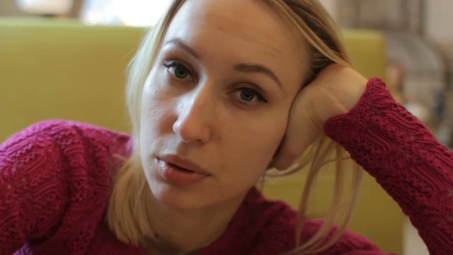 Close Up Portrait Of A Young Attractive Blonde Woman Talking With Camera