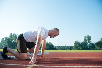 Runners preparing for race at starting blocks