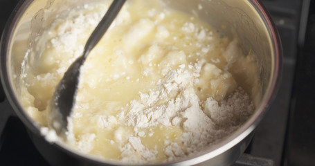 Handheld shot of mixing flour with butter mix for making choux dough, 4k photo
