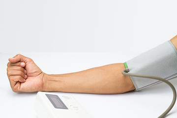 man measureing his blood pressure on white desk on white background