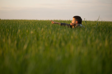 The teenager lies in the tall grass at sunset
