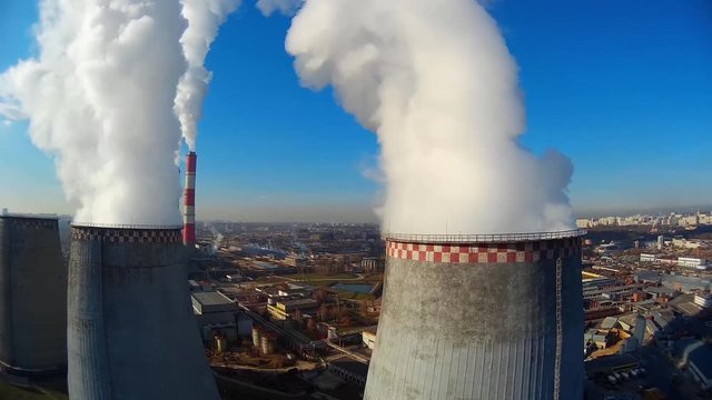 Company of the Moscow energy system. Important industrial district. Fog and smoke Huge pipes with emerging white large clouds of steam. Moscow Russia. Summer blue sky. Unique Aerial  Flight close to