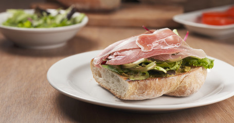 shot of speck put on ciabatta bread preparing sandwich, 4k photo