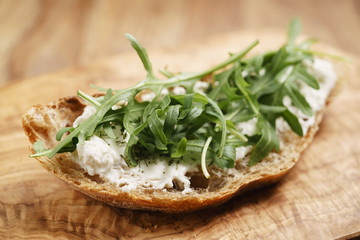 arugula on rustic bread with ricotta cheese, shallow focus
