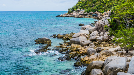 Costline of Koh Tao Islands in Thailand. Granite Rocks and blue clear water hitting Rocks