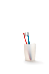 Toothbrushes in a mug on white