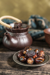 date palm for Ramadan, date palm fruits and Tea on a metal tray placed on a glitter sparkle background.