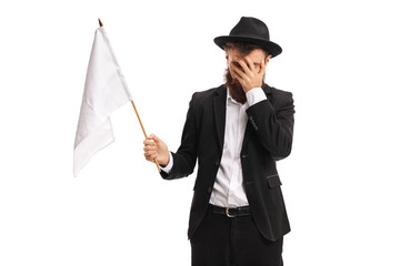 Man with a white flag holding his head in disbelief