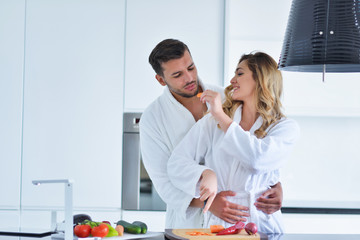 Happy couple cooking breakfast together in the kitchen