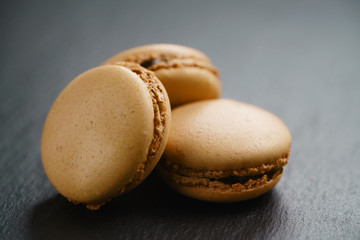 caramel brown macarons on slate background, shallow focus