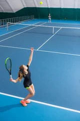 Foto op Canvas The young girl in a closed tennis court with ball © master1305