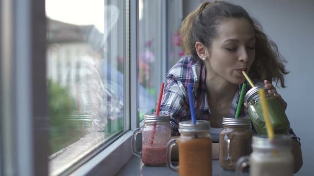 girl choosing healthy fruit colorful smoothies for drink. Dolly shot