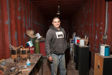 Portrait of builder in shipping container looking at camera smiling